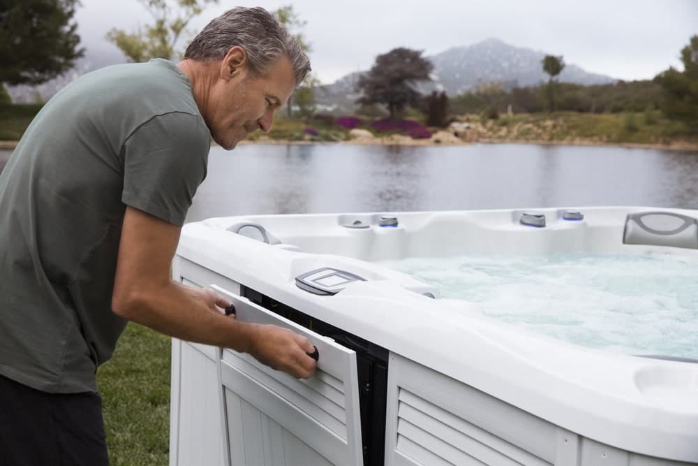 man is checking hot tub's filters